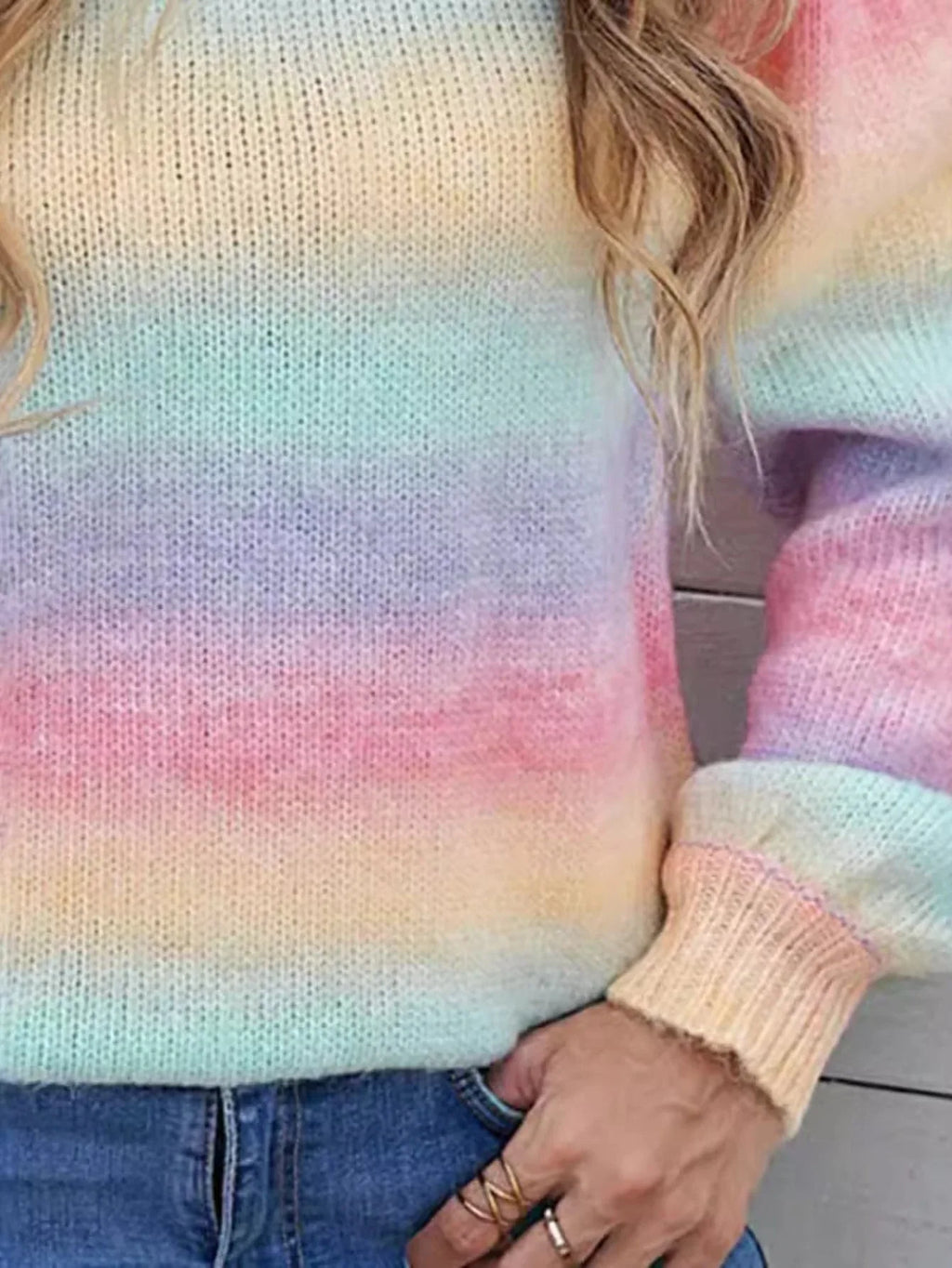 Close-up of the rainbow gradient knit sweater showing the texture and colors.