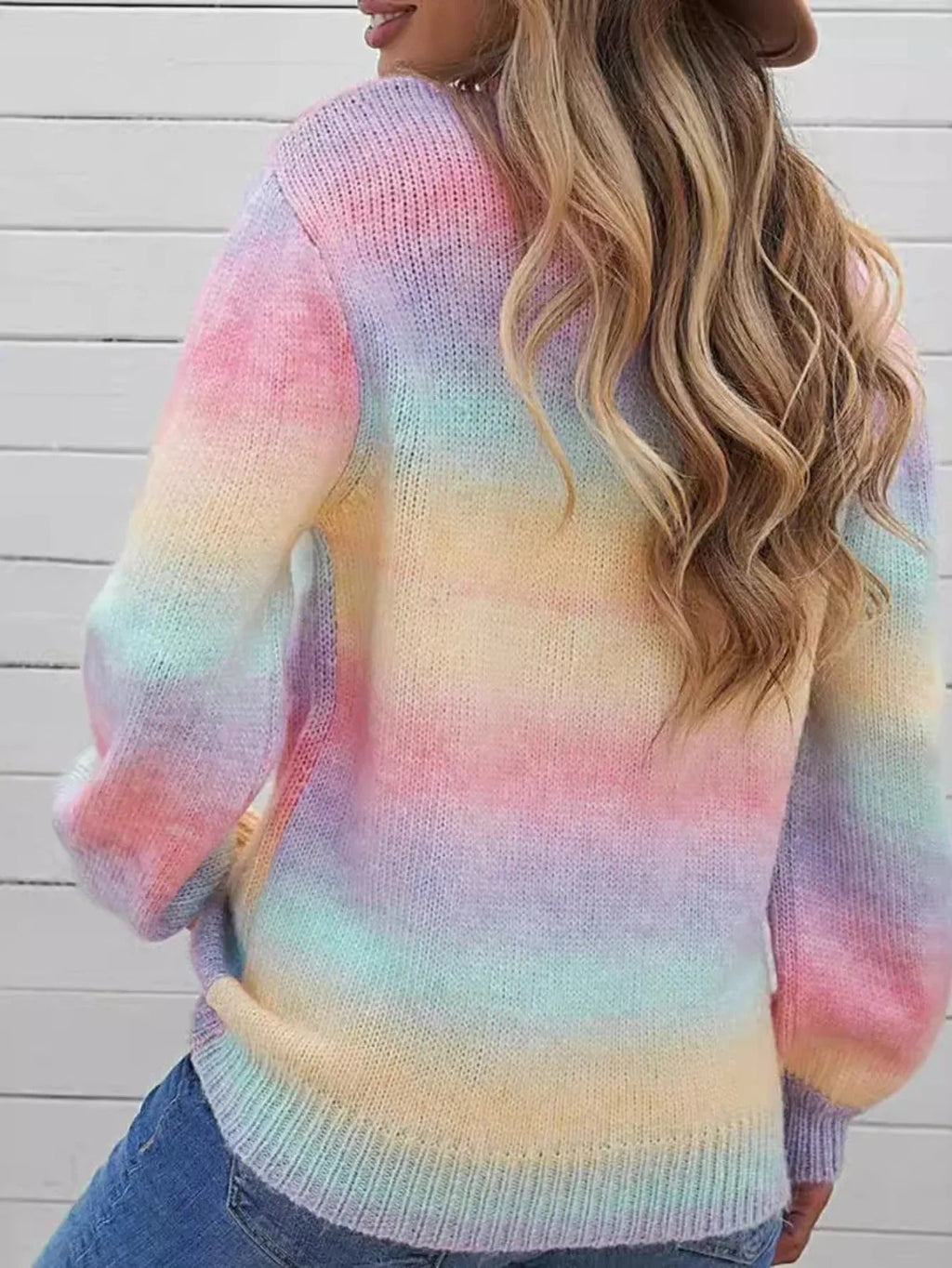 Back view of a woman wearing a rainbow gradient knit sweater.