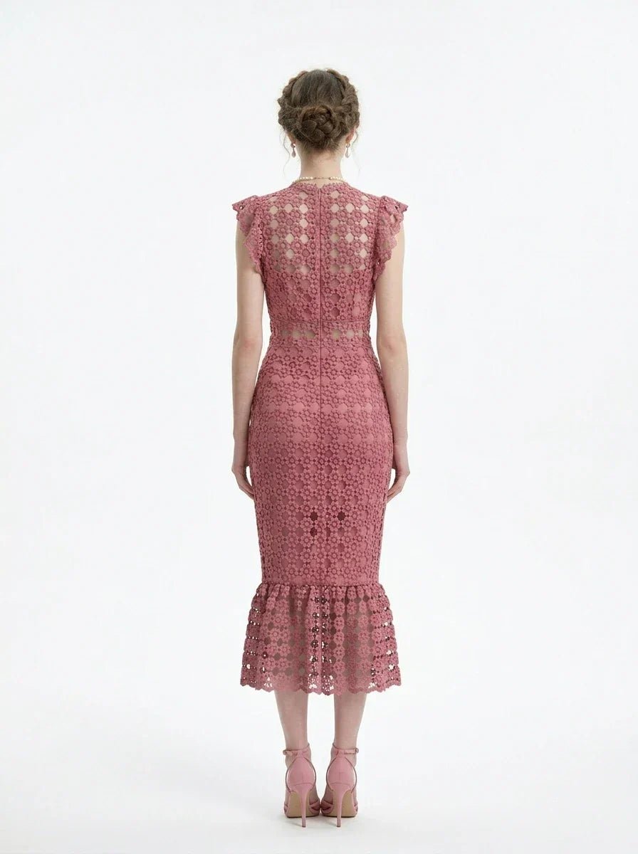 Woman wearing a pink lace dress with ruffled cap sleeves and a mermaid hemline, back view.