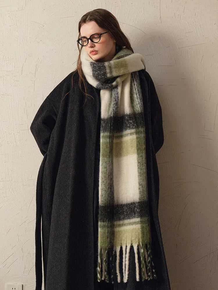 woman wearing a dark coat and a green and white plaid scarf