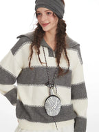 Close-up of a model wearing a striped knit sweater, showing the details of the garment