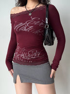 Model wearing the burgundy top, grey skirt, and a black handbag.