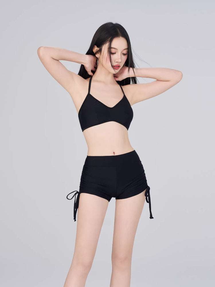 Model wearing a black bikini top and black drawstring shorts