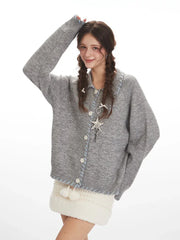 Close-up of a model wearing a grey knitted cardigan with a white textured mini skirt, showcasing the collar and necklace.