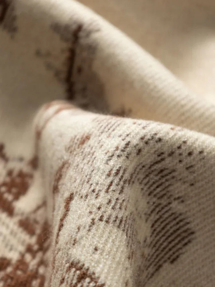 Close-up of the woven texture of a cream fabric with a brown pattern
