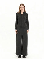 Model wearing a charcoal grey knit zip-up jacket and matching wide-leg pants, front view.