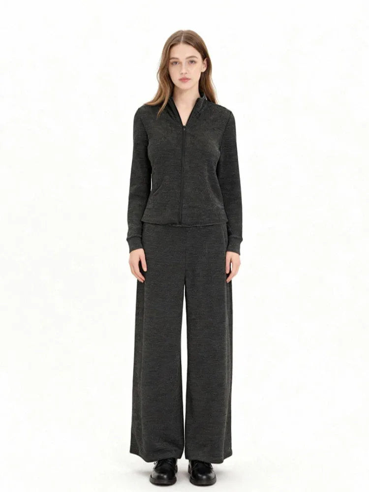 Model wearing a charcoal grey knit zip-up jacket and matching wide-leg pants, front view.