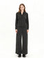 Model wearing a charcoal grey knit zip-up jacket and matching wide-leg pants, front view.