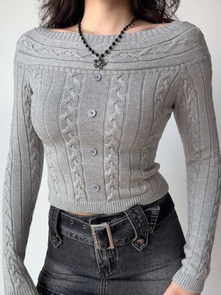 Close-up of a grey cable knit cropped sweater with an off-the-shoulder neckline and button details.