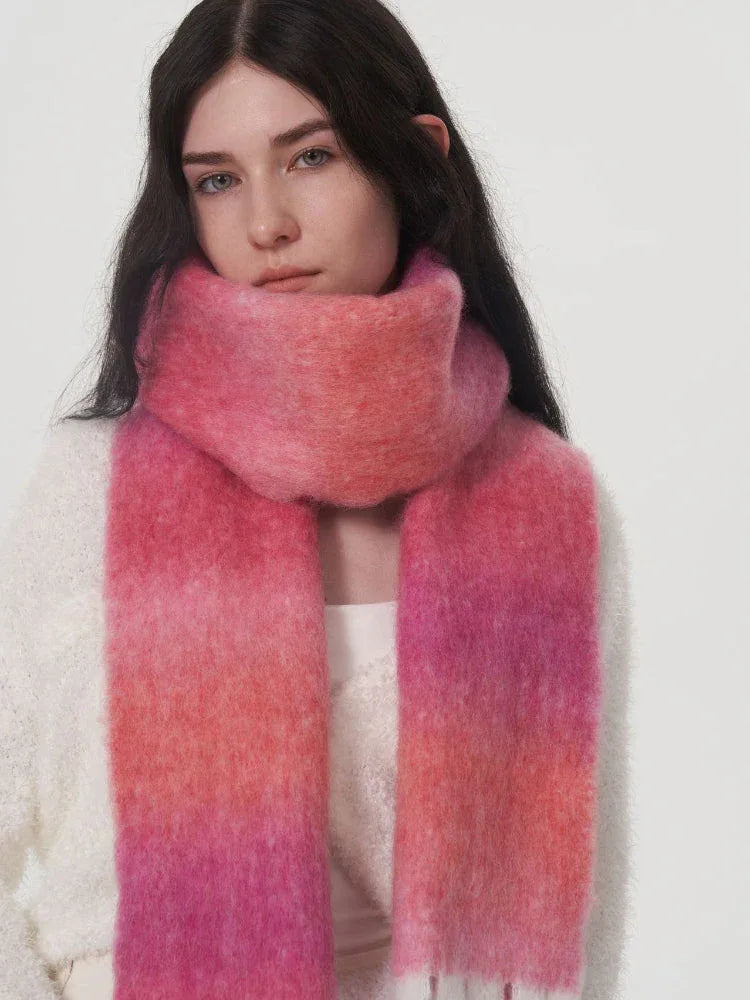 Woman wearing a pink and orange gradient scarf around her neck.