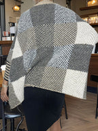 Back view of a woman wearing a geometric pattern knit poncho