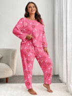 Woman wearing pink heart-print pajamas, standing and adjusting her waistband.