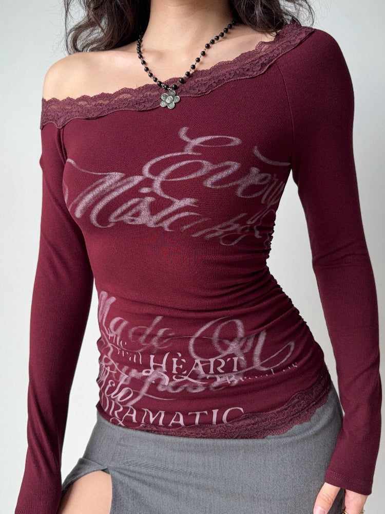 Model wearing a burgundy off-the-shoulder long-sleeve top with lace trim and a graphic print.