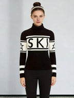Woman wearing a black and white turtleneck ski sweater with the word "SKI" printed across the chest and stars on the sleeves.