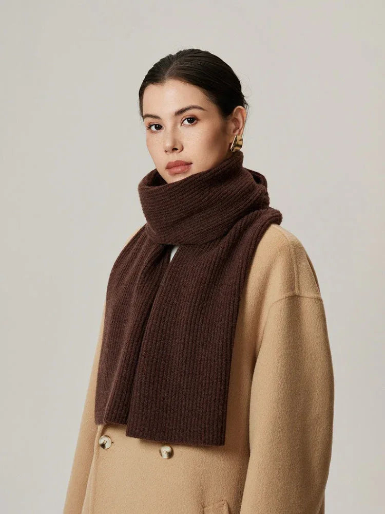 Woman wearing a brown ribbed knit scarf over a beige coat.