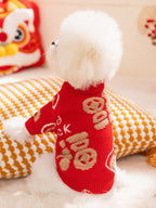 Rear view of a white Bichon Frise dog in a red knit sweater with gold embroidered Chinese characters.