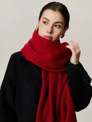 Woman wearing a black coat and a solid red scarf