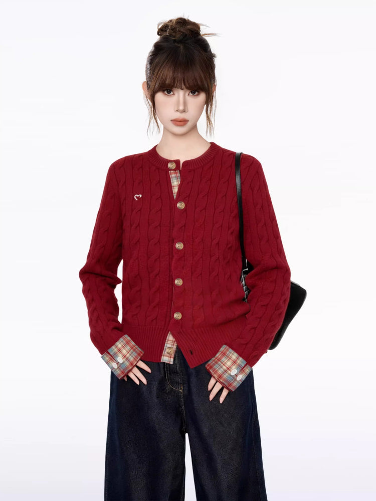 Close-up of the red cable knit cardigan, showing the button detail and embroidered heart.