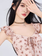 Close-up of the pink floral print mini dress showing the square neckline, tie front, and ruffle details.