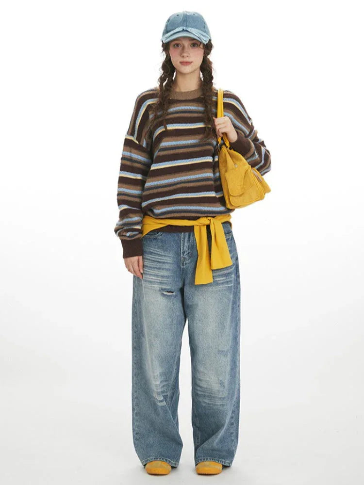Model wearing a striped knit sweater, wide-leg jeans, and a yellow bag, front view. Main image
