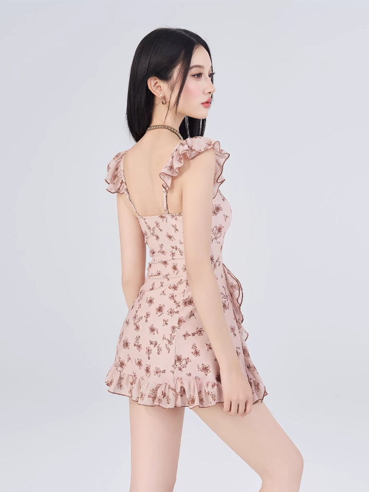 Rear view of a woman wearing a pink floral print mini dress with ruffle trim.