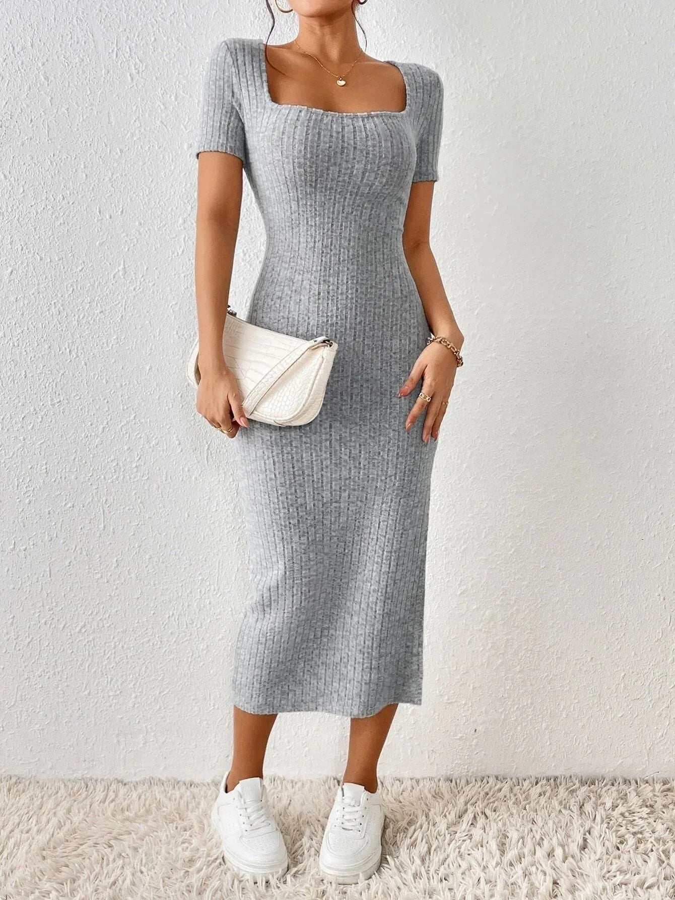 Woman wearing a grey ribbed knit midi dress with short sleeves, a square neckline, and a white handbag.