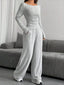 Model wearing a grey ribbed knit long sleeve top and wide leg pants set, standing indoors.