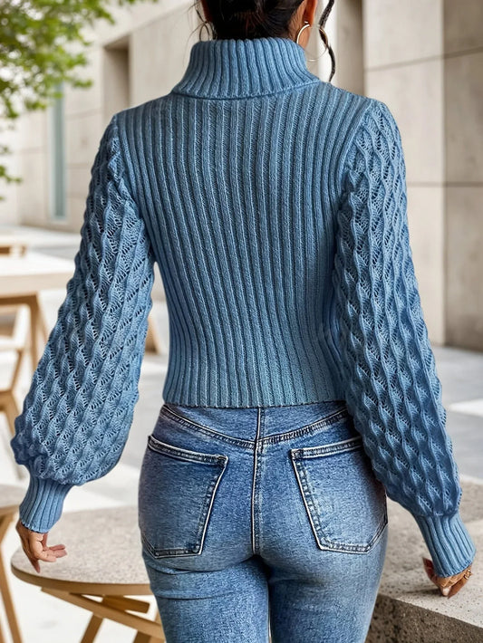 Back view of a woman wearing a blue knit turtleneck top with a cut-out detail and balloon sleeves.