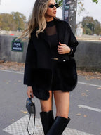 Woman wearing a black wool blend coat with faux fur accents, black top, and black boots.