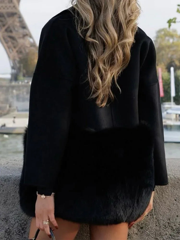 Rear view of a woman wearing a black wool blend coat with faux fur accents.