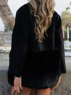 Rear view of a woman wearing a black wool blend coat with faux fur accents.