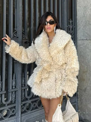 woman in a cream faux fur coat with a large collar and a belt, posing outdoors