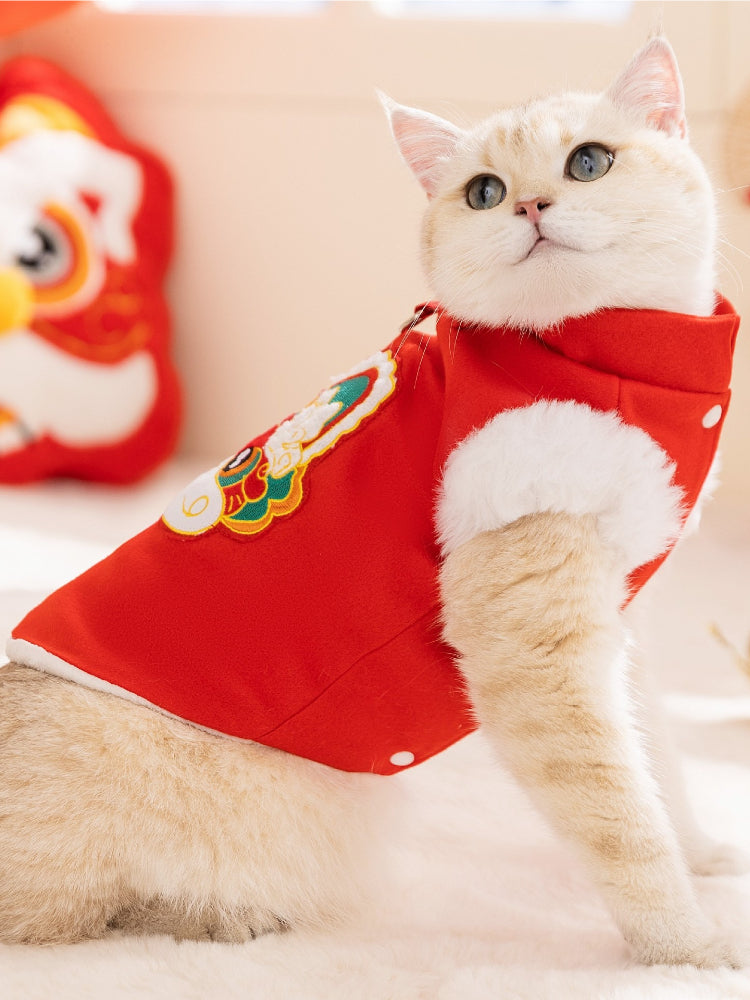 Side view of a cat wearing a red Chinese-style vest with white trim.