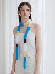 Model wearing a white ribbed tank top and off-white pants with a long, fluffy, color-blocked scarf hanging down.