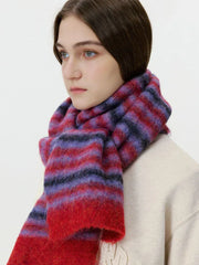 Close-up side profile of a woman wearing a red and purple striped fuzzy scarf