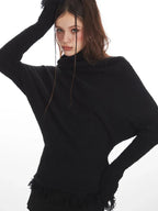 Close-up of a woman wearing a black turtleneck sweater with a textured knit fabric.