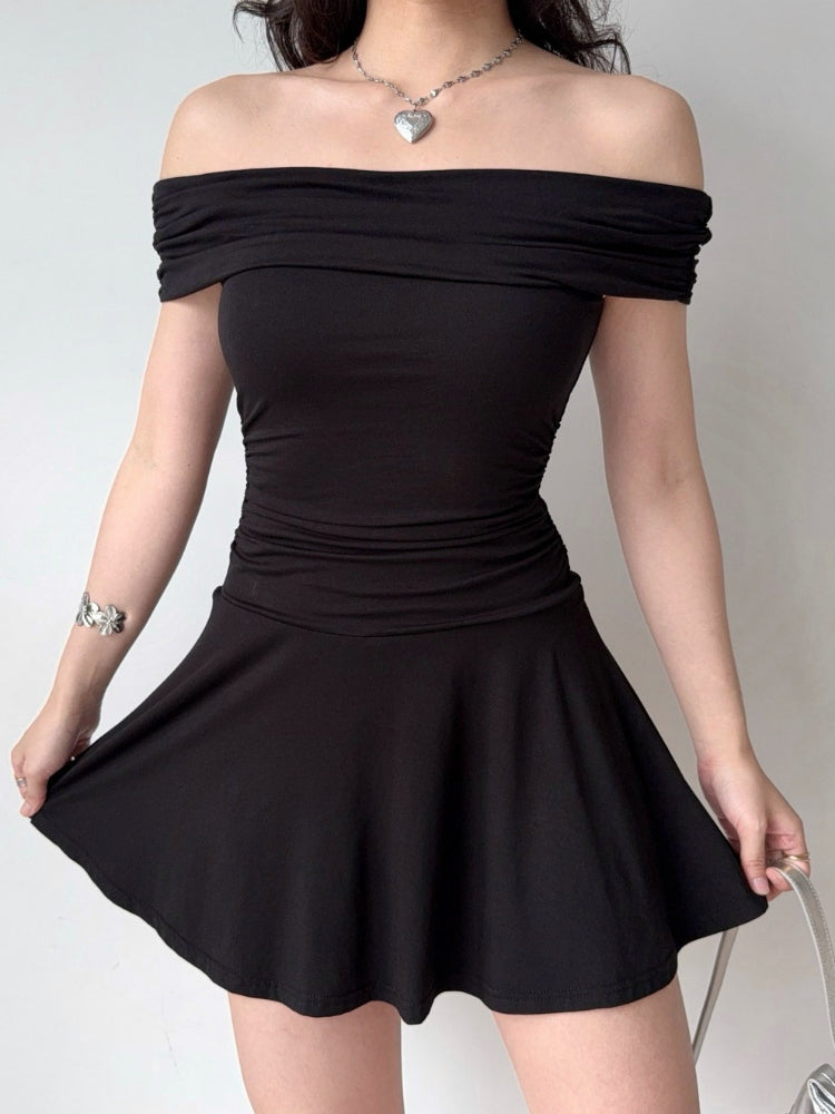 Woman showing the flared skirt of a black off-the-shoulder knit dress.