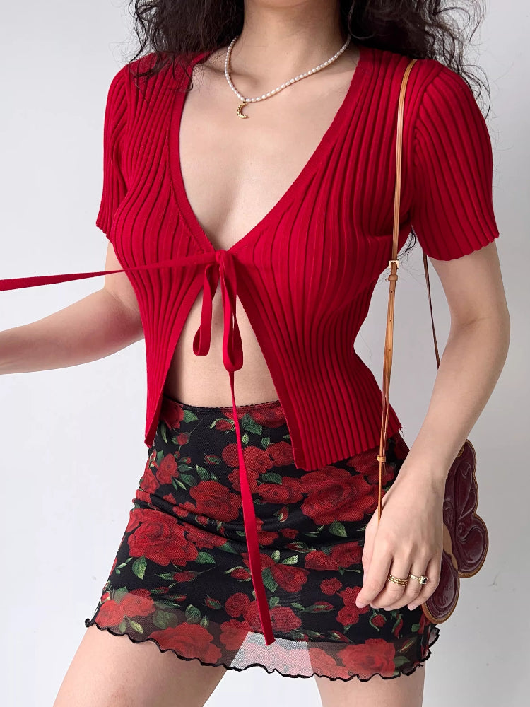 Model wearing a red ribbed knit tie-front crop top with a floral print skirt.