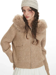 Detailed view of the faux fur trim hood on a beige ribbed knit jacket.