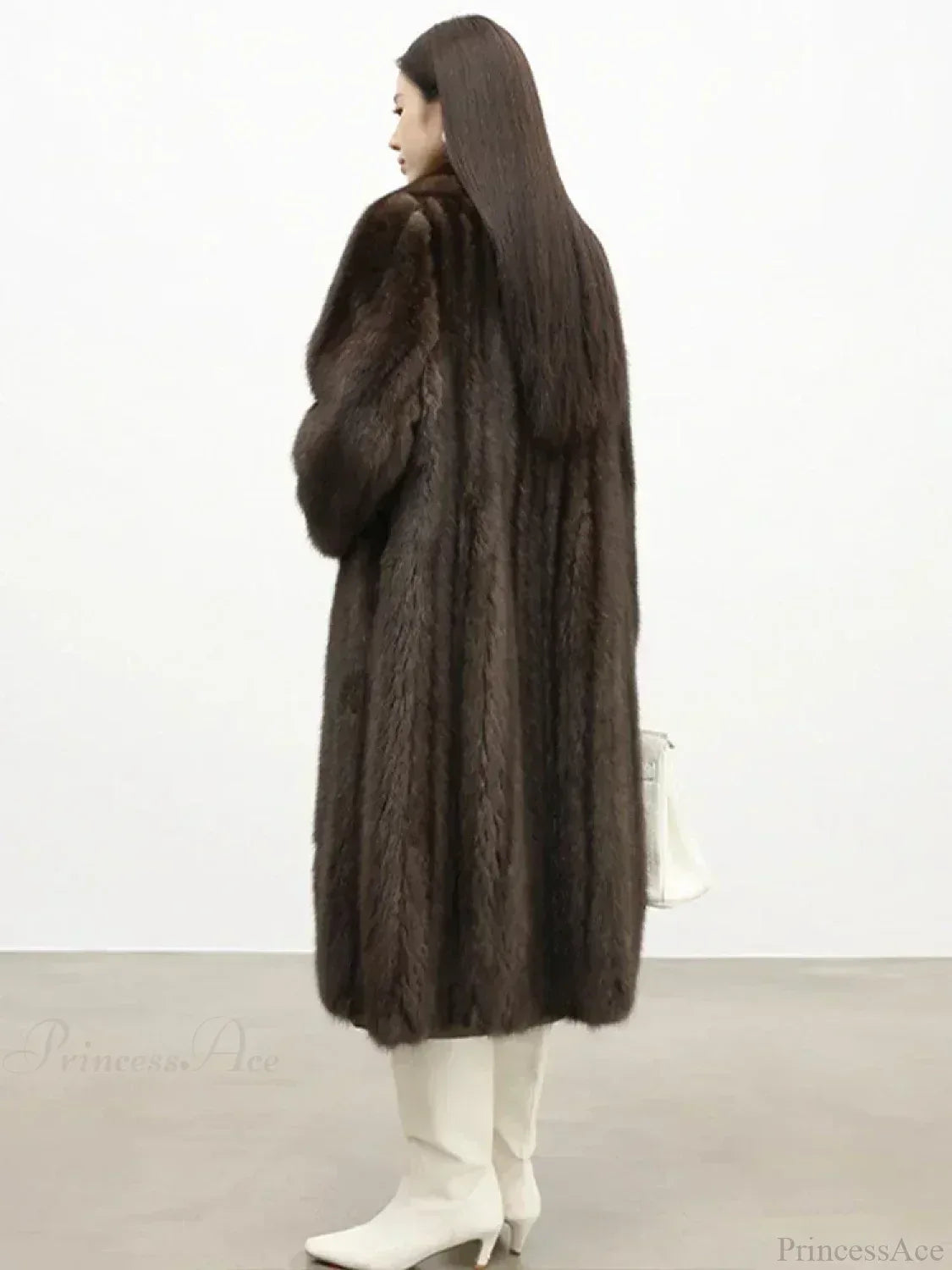 Back view of a woman in a brown mink fur coat and white boots.
