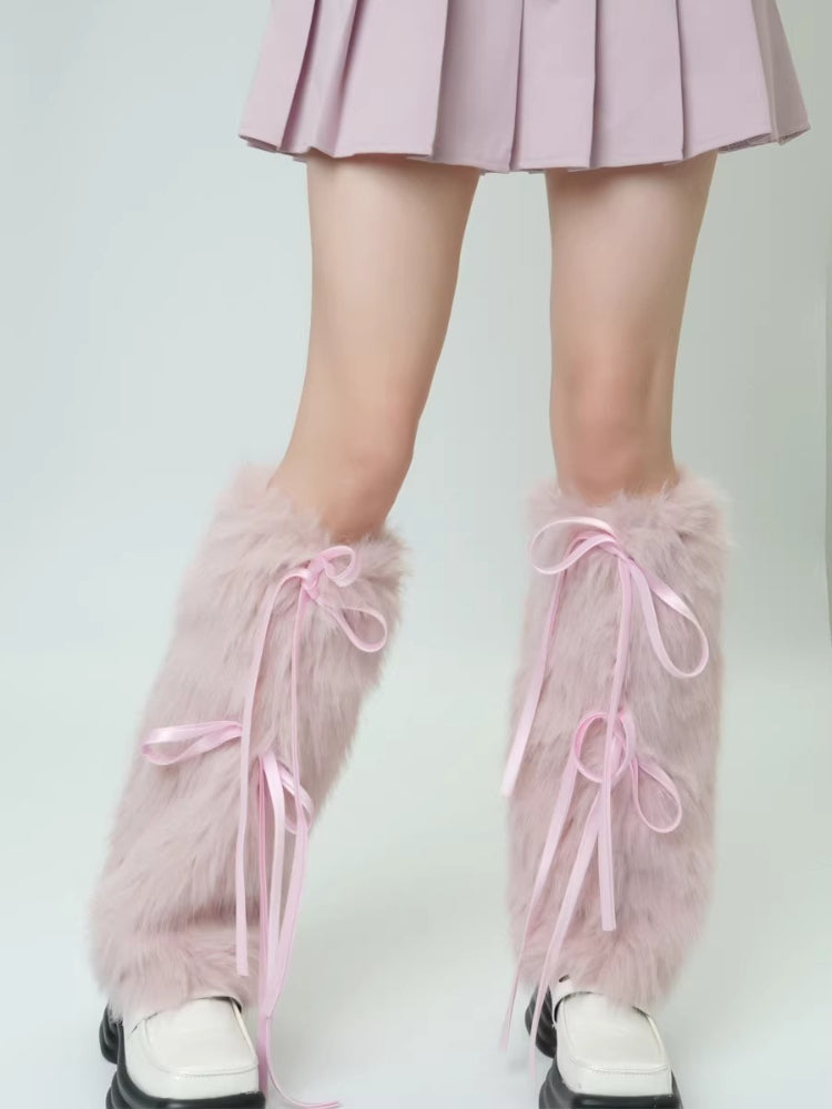 Close-up of pink faux fur leg warmers with ribbon ties, worn over white shoes.