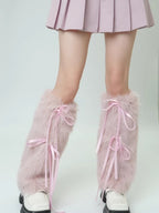 Close-up of pink faux fur leg warmers with ribbon ties, worn over white shoes.