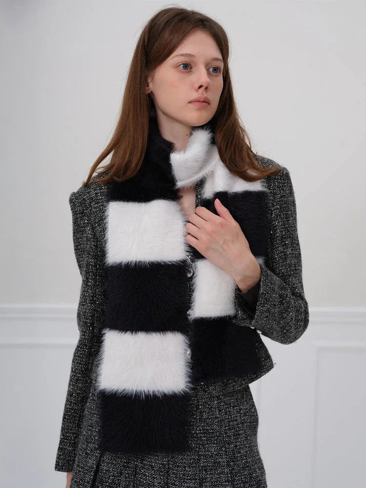 Woman adjusting a black and white checkered faux fur scarf