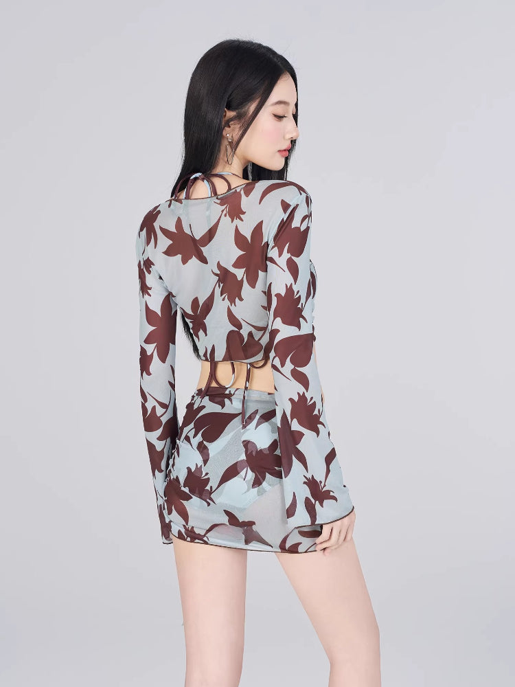 Rear view of a woman in a light blue and brown floral print sheer mesh two-piece set.