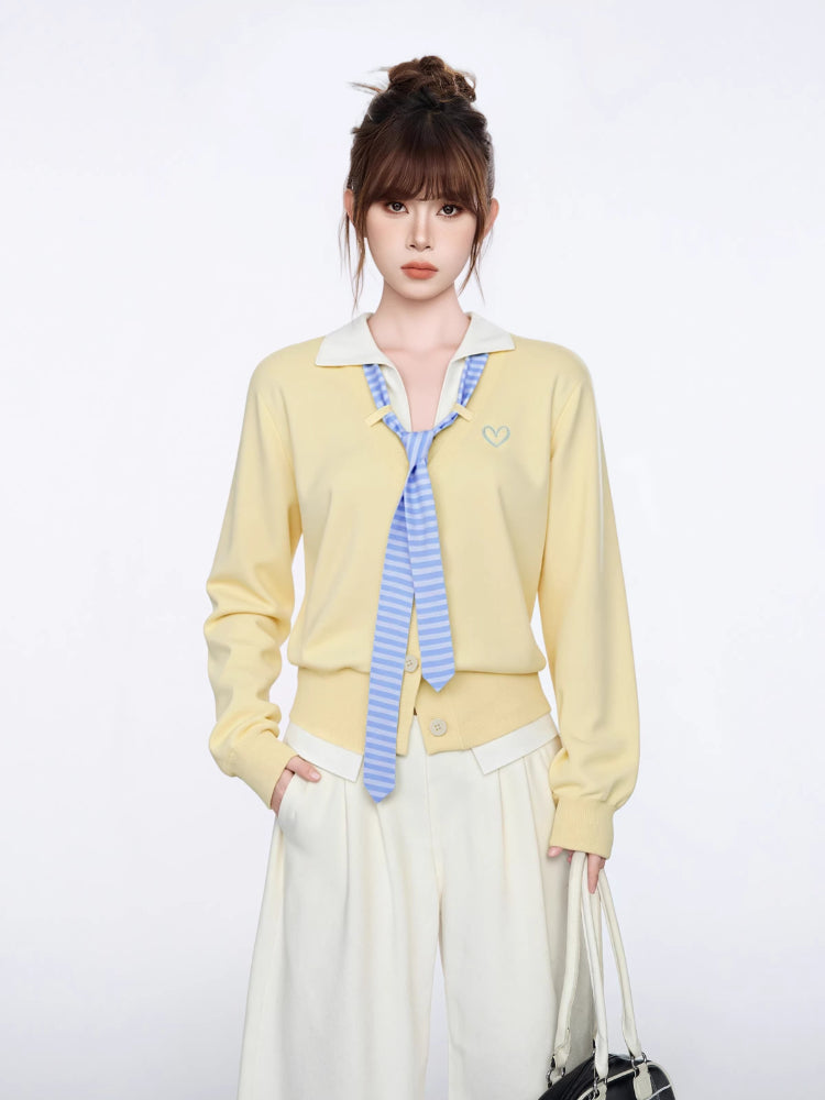 Close-up of the yellow knit cardigan with embroidered heart detail.