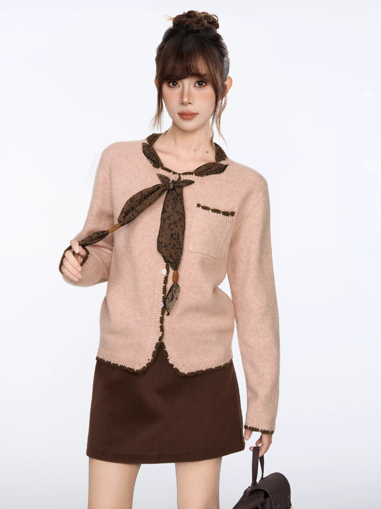 Close-up of the pink knit cardigan, showing the scarf detail and pocket.