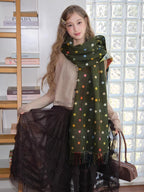 Woman in a dark green polka dot scarf and a ruffled dark skirt.