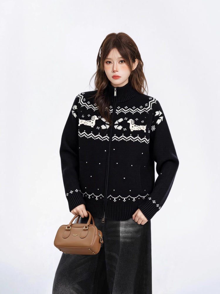 Close-up of the front of a black zip-up knit sweater with a white fair isle dog pattern.