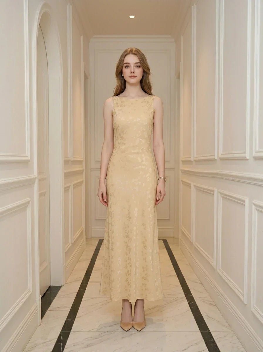 Woman wearing a sleeveless yellow maxi dress with a floral jacquard pattern standing in a hallway.