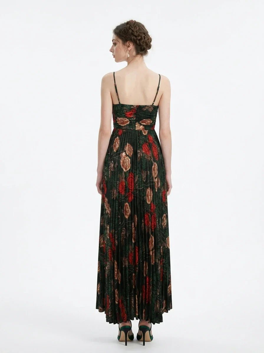 Woman wearing a dark green floral print maxi dress with spaghetti straps and a pleated skirt, back view.
